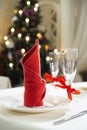 Christmas table setting background with tableware and fir tree on a backdrop. Royalty Free Stock Photo