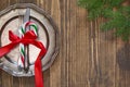 Christmas table setting with candy cane and red ribbon as decor, vintage dishware, silverware and decorations on board. Royalty Free Stock Photo