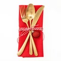 Christmas table setting, celebration dinner. Golden cutlery and red napkin isolated on white, top view Royalty Free Stock Photo