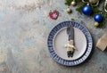 Christmas table setting on decor background. Blue and gray plate, cutlery, festive decorations Royalty Free Stock Photo