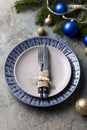 Christmas table setting on decor background. Blue and gray plate, cutlery, festive decorations Royalty Free Stock Photo