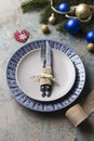 Christmas table setting on decor background. Blue and gray plate, cutlery, festive decorations Royalty Free Stock Photo