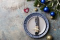 Christmas table setting on decor background. Blue and gray plate, cutlery, festive decorations Royalty Free Stock Photo