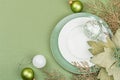 Christmas table setting with ceramic plates, traditional decor on Savannah Green color background