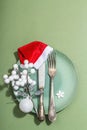 Christmas table setting with ceramic plates, traditional decor on Savannah Green color background