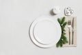 Christmas table setting with empty white plate and silver decorations. New Year serving on white background. Festive dinner. Copy Royalty Free Stock Photo