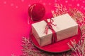 Christmas table setting with a festive gift box in trendy Viva Magenta color background. New Year Royalty Free Stock Photo