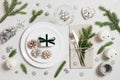 Christmas table setting with festive silver decorations, fir branches and cones on white background. Preparing for Christmas Royalty Free Stock Photo