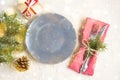 Christmas table setting with gift grey plate on white table. Xmas concept top view