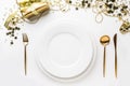 Christmas table setting with golden cutlery and decor on white background. Top view Royalty Free Stock Photo