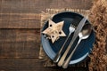 Christmas table setting. Knife, fork, spoon and plate with New Year`s scenery. on a brown wooden table. view from above . new Yea Royalty Free Stock Photo