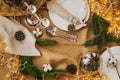 Christmas table setting. New Year`s decor: fir cones and branches, cotton balls, a garland and silver cutlery