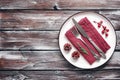 Christmas table setting. Plate, cutlery and napkin on an old dark wooden table. Top view, flat lay. Noel Royalty Free Stock Photo