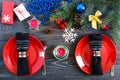 Christmas table setting. Red plate, fork, knife, candle, napkin, gifts branch of a Christmas tree Royalty Free Stock Photo