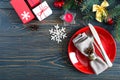 Christmas table setting. Red plate, fork, knife, candle, napkin, gifts branch of a Christmas tree Royalty Free Stock Photo