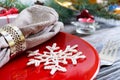 Christmas table setting. Red plate, fork, knife, candle, napkin, gifts branch of a Christmas tree Royalty Free Stock Photo