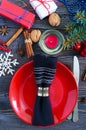 Christmas table setting. Red plate, fork, knife, candle, napkin, gifts branch of a Christmas tree Royalty Free Stock Photo