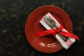 Christmas table setting , red plate, vintage cutlery and napkin tied with a ribbon on a dark rustic background.Top view, flat lay Royalty Free Stock Photo