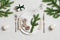 Christmas table setting with silver cutlery, gift and fir branches on a gray background. View from above Royalty Free Stock Photo