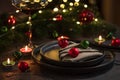 Christmas Table Setting with Tree-Shaped Napkin and Tealight Candles against Christmas lights Royalty Free Stock Photo