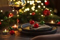 Christmas Table Setting with Tree-Shaped Napkin and Tealight Candles against Christmas lights Royalty Free Stock Photo