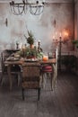 Christmas table setting. Vintage chairs, natural pine tree branches, candles. Rural or rustic style decorations Royalty Free Stock Photo