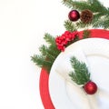 Christmas table setting with white dishware, silverware and red decorations on white background. Top view. Royalty Free Stock Photo