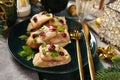 Christmas table with small canapes with smoked herring fillets in oil with cranberries