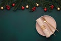 Christmas table top view: empty plate, golden cutlery. Festive setting, New Year decorations. Shiny baubles, fir branches,