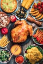 Christmas or Thanksgiving whole roasted chicken, rice, pumpkin, corn, honey, nuts, vegetable salads over wooden Royalty Free Stock Photo