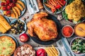 Christmas or Thanksgiving whole roasted chicken, rice, pumpkin, corn, honey, nuts, vegetable salads over wooden Royalty Free Stock Photo