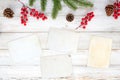 Christmas theme background with blank photo paper and decorating elements on white wood table. Royalty Free Stock Photo