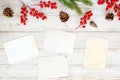 Christmas theme background with blank photo paper and decorating elements on white wood table. Royalty Free Stock Photo