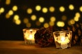 Christmas theme with candles, snow, pine cone and christmas light Royalty Free Stock Photo