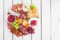 Christmas theme charcuterie board. Overhead view against white wood.