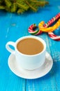 Christmas theme. A cup of coffee with milk cappuccino, in the form of bright candy canes and green spruce branches Royalty Free Stock Photo