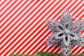 Christmas theme. Red-white striped background. Christmas Silver star. Spruce branch. Copy space. Postcard Royalty Free Stock Photo