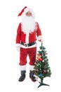 Christmas theme - Santa Claus holding christmas tree and his bag full of gifts over white background. Santa Claus christmas. Royalty Free Stock Photo