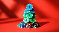 Christmas-themed stacked casino chips forming tree, solid red background Royalty Free Stock Photo