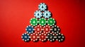 Christmas-themed stacked casino chips forming tree, solid red background Royalty Free Stock Photo