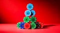 Christmas-themed stacked casino chips forming tree, solid red background Royalty Free Stock Photo
