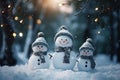 Christmas, three cheerful snowmen in the forest in the light of electric lamps during a snowfall, the meeting of Christmas and New