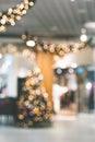 Christmas three with soft bokeh lights in the shopping center blurred out of focus background