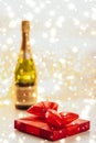 New Years Eve holiday champagne bottle and a gift box and shiny snow on marble background Royalty Free Stock Photo