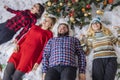 Christmas time happy people company of friends in festive room with decorated tree soft white floor