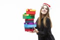 Christmas Time Ideas. Portrait of Happy Caucasian Brunette Santa Girl Holding Heap of Colorful Gift Boxes Wrapped Up with Ribbons Royalty Free Stock Photo