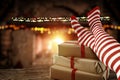 Christmas time, legs in winter socks, elf stockings. Space for your text or decoration. Old fireplace wall background. Royalty Free Stock Photo