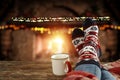 Christmas time, legs in winter socks. Space for your text or decoration. Old fireplace wall background.