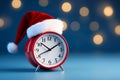 Christmas time. Red alarm clock with santa hat on Blue Background. Christmas sales, countdown to the New Year Royalty Free Stock Photo