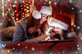 Smiling family mother and daughter in santas hats and pajamas watching funny video or choosing gifts on digital tablet Royalty Free Stock Photo